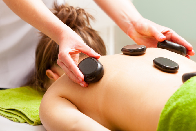 Spa Salon. Woman Relaxing Having Hot Stone Massage. Bodycare.